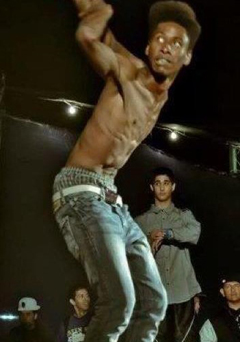 dancer streches arms behind him