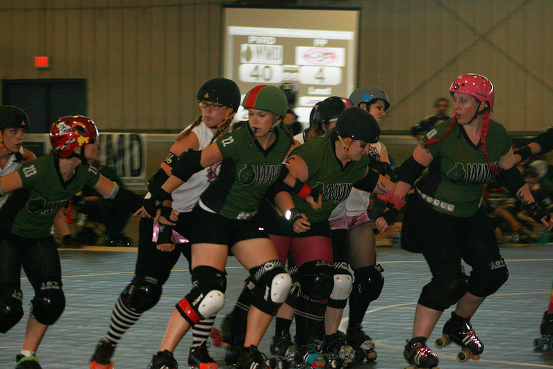 roller derby skaters racing and shoving